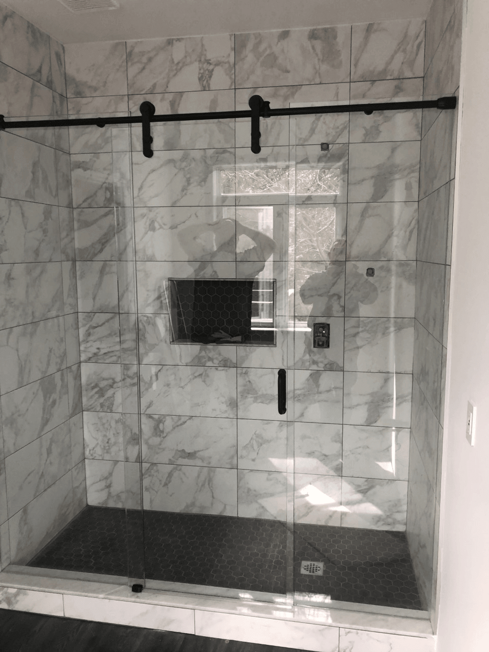 Matte black frameless sliding glass shower doors installed by Access Glass Inc. in Wasaga Beach, ON